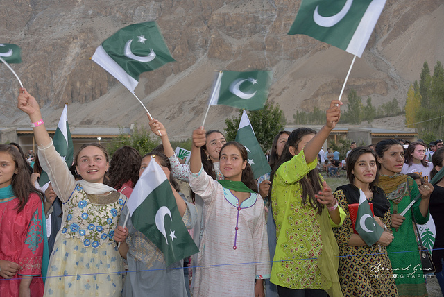 Jeunes femmes de la haute vallée de la Hunza agitant des drapeaux pakistanais lors du festival FACE © Bernard Grua